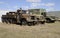 Three old army vehicles parked in a grass field