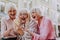 Three old females looking at the phone and laughing