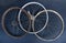 Three old rusty bike wheels on dark background