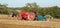 Three old vintage red and blue tractors ploughing