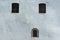 Three old windows on ancient white wall. Windows in rectangular and oval frames