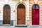 Three old wooden arched doors, brown and red, in Valletta, Malta