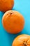 Three orange blood oranges on teal background