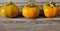 Three orange kaki persimmons in a row