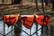 three orange lifejackets hang on the railing near the pier at the boat station. Gatchina, Russia.