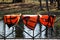 three orange lifejackets hang on the railing near the pier at the boat station. Gatchina, Russia.