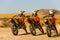 Three orange motorbikes in the Sahara desert