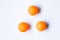 Three orange ping pong balls on white background.