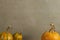 Three orange pumpkins on a background of home-woven fabric. Place for text