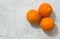 Three Oranges on a Marble-like Background