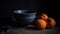 three oranges sitting next to a bowl on a table