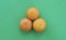 Three oranges stand out next to each other on a green background