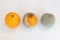 Three oranges in various stages of decomposition. Overhead shot on white background.