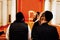 three Orthodox Jews in kippahs back on red