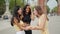 Three overjoyed multiracial female friends embracing and feeling excited to meet outdoors