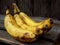 Three overripe bananas on a dark wooden background. selective focus.