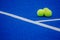 Three paddle tennis balls on a paddle tennis court