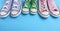 Three pair of old worn textile sneakers on a blue background