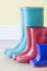 Three Pairs Of Colorful Gumboots In A Row