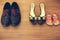 Three pairs of shoes: men, women and children. Baby sandals stand next to womens shoes.