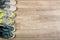 Three pairs of various running shoes laid on a wooden floor background.