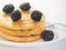 Three pancakes with blackberry on white