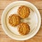 Three Pandan MoonCake in a plate on wooden background. Aerial view.