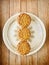 Three Pandan Mooncake in a plate on wooden background. Vertical.