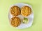 Three Pandan Seed paste MoonCake with a portion cutout, green background.