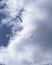 Three parachutes flying over the blue sky with clouds.