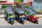 Three parked Tuk-Tuks on a pavement waiting to transport tourists and locals