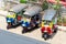 Three parked Tuk-Tuks on a pavement waiting to transport tourists and locals