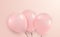 Three party balloons with blank space for advertisement on pastel pink background. Realistic vector image.