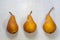 Three pears scientific name Pyrus communis `Bosc` close-up on a light background. The concept of a rich harvest, fruits, organic