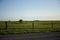 Three people horseback riding in rural farmland