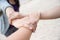 Three people join hands together on white sand beach background.