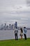 Three people looking at Seattle Skyline from Alki Beach in West Seattle