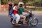 Three people on a motocycle driving in the street, New Delhi, In