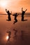 Three people silhouettes jumping on the beach