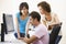 Three people sitting in computer room