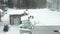 Three people throw snow off the roof