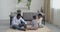 Three people young adorable parents African American woman wife mom and man husband dad sitting on floor with their