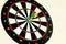 Three perfect darts shoot at the target darts different color red yellow and green