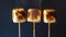 Three Perfectly Toasted Marshmallows On Wooden Sticks With A Dark Background