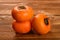 Three persimmons on wooden table