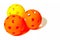 Three Pickleballs - 2 Orange and 1 Yellow together on a white background.