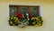 Three-piece wooden euro-window / plastic window and boxes with yellow and red begonia.