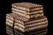 Three pieces of brown and white puff waffle cakes with boiled condensed milk isolated on black background with reflection on