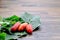 Three pieces of Red ripe ivy gourd with their green leaves