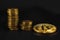 three piles of coins in ascending order, and a Golden coin bitcoin on black leather